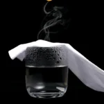 Vaso con agua y vapor saliendo, cubierto por tela.