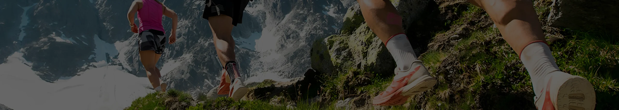 Corredores en montaña con nieve y rocas